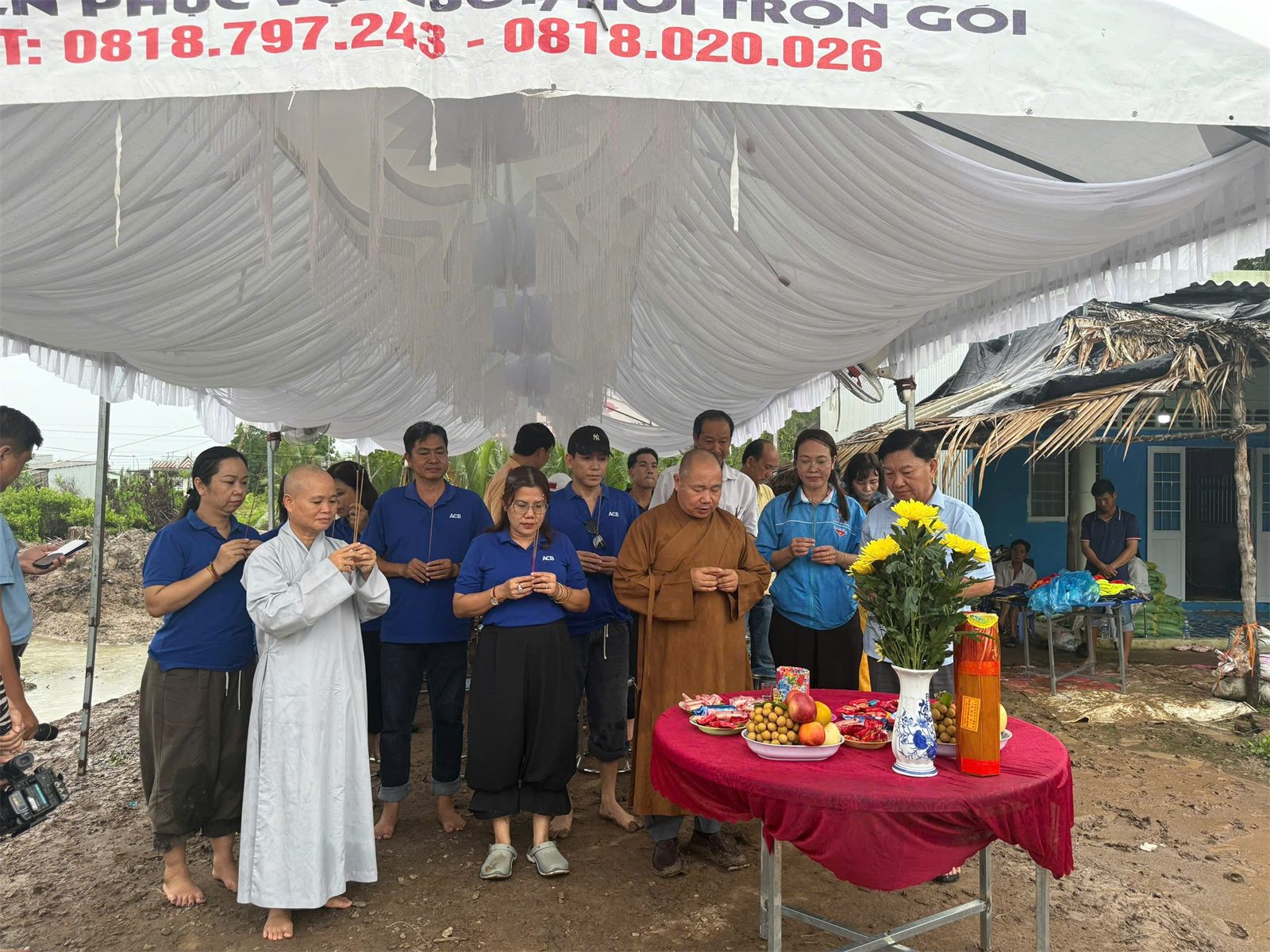 Những người đồng hành đứng trước bàn lễ và cầm hương trong ngày khánh thành